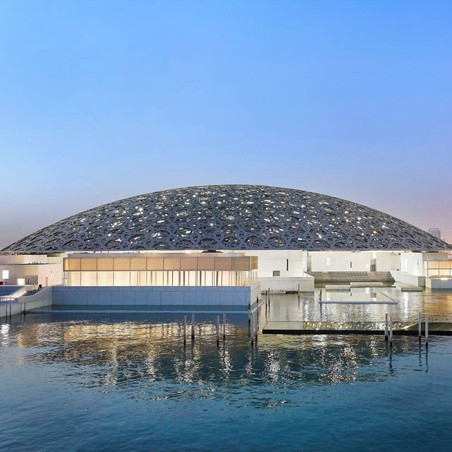 The Louvre Museum Abu Dhabi, a white domed structure reflecting in the Arabian Sea