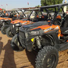 Line of orange ATVs parked at an angle in the Dubai desert, ready for a safari adventure.