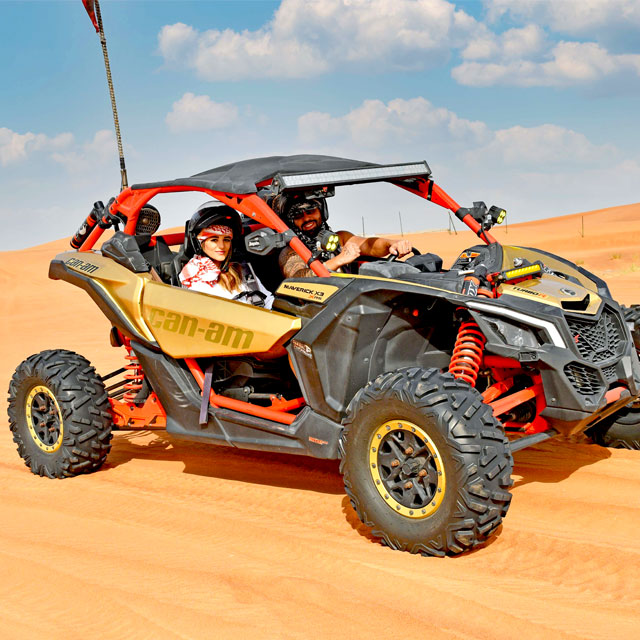 Romantic desert adventure: a couple explores the dunes on a two-seater Polaris