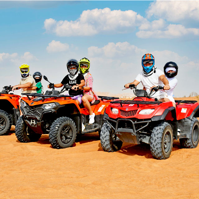 Family and couple riding quad bikes together in Dubai desert
