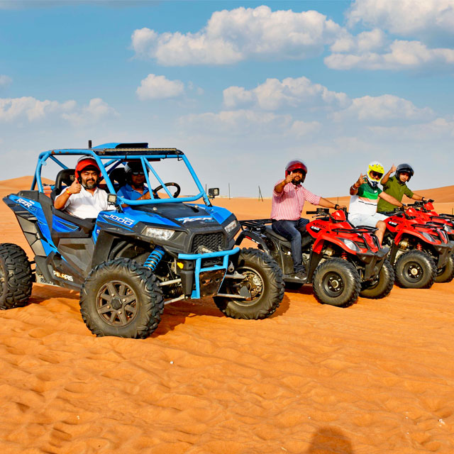 Friends enjoying a thrilling group adventure on quad bikes and a Polaris in the Dubai desert.