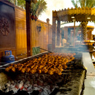 BBQ being grilled on charcoal during camp site activities at Prime Dubai Dunes Safari