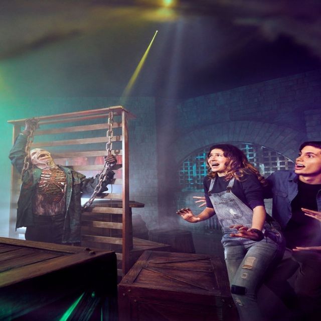 A couple experiencing a fright as they encounter a skeleton in the haunted hotel at IMG Worlds of Adventure