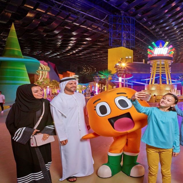 A happy family posing for a selfie with the lovable Darwin Watterson mascot at IMG Worlds of Adventure