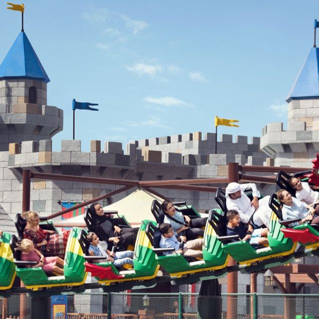 Excited family experiencing the thrill of Dragon's Apprentice rollercoaster at LEGOLAND Dubai