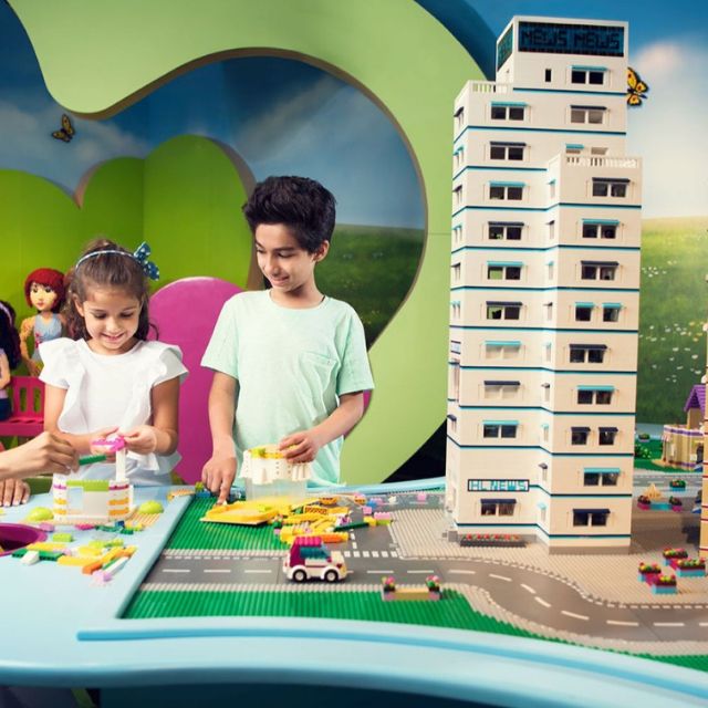 Children immersed in imaginative play, constructing creations with LEGO bricks