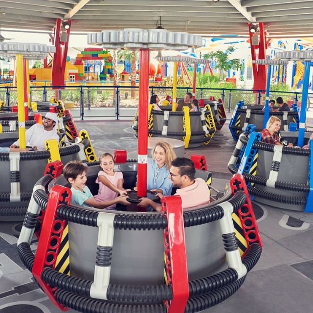 Excited family enjoying the swinging sensation of the LEGO Technic Twister at LEGOLAND Dubai