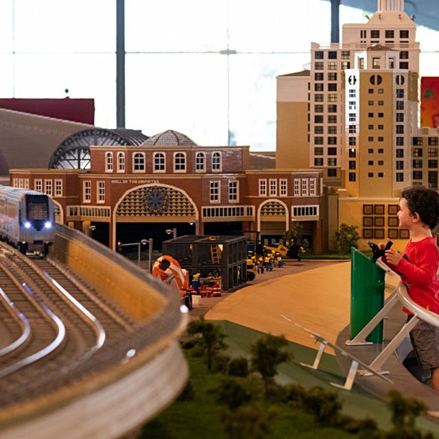 A child engaging with the interactive LEGO model of the Dubai Metro at LEGOLAND Dubai's Miniland