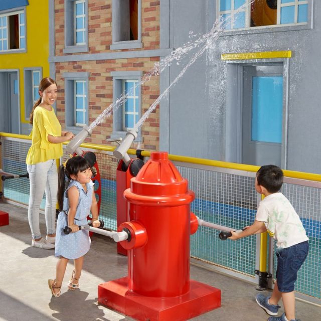 Children engaged in imaginative play with fire hydrants at the Rescue Academy in LEGOLAND Dubai