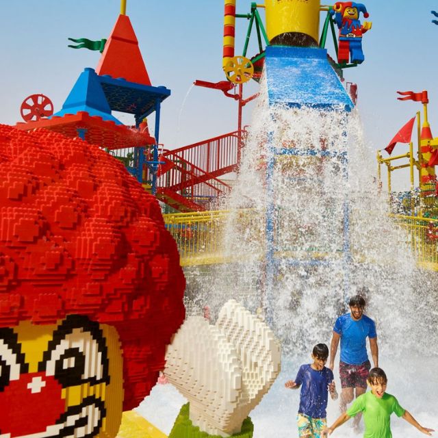 Close-up of Joker LEGO structure in LEGOLAND Water Park, with a child playing in the water area in the background.