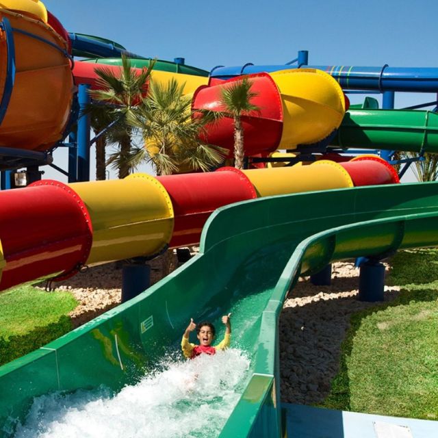Thrilled child giving a thumbs up after an exciting water slide ride at LEGOLAND Water Park