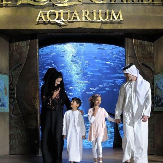 A family of four enjoying a memorable moment at the entrance of Atlantis Lost Chambers Aquarium