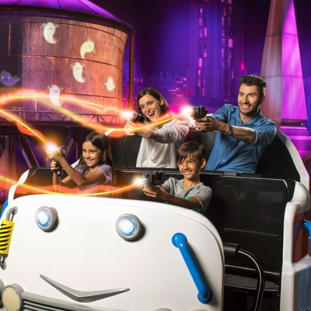 Family having a blast shooting proton packs during the Ghostbusters – Battle for New York ride at Motiongate Dubai